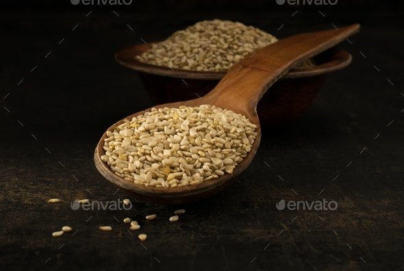 A wooden spoonful of sesame seeds