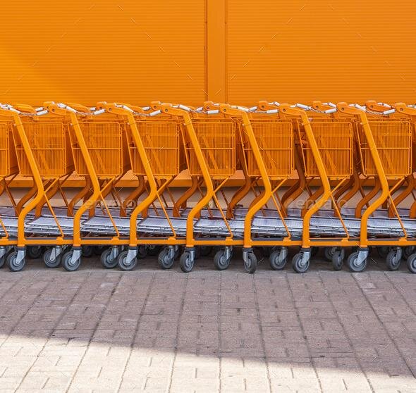 Orange shopping cart stacked by the entrance