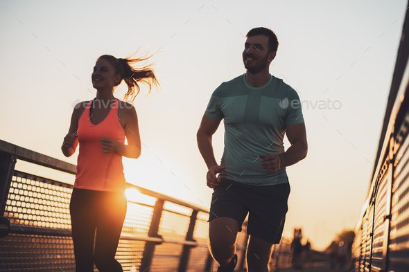 Happy couple jogging in sunset