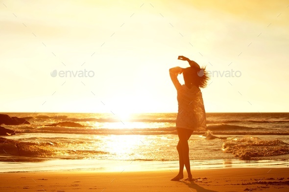   Silhouette portrait young woman walking on beach during sunset